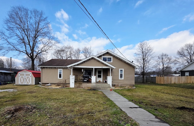 bungalow with a shed, a front lawn, and a porch