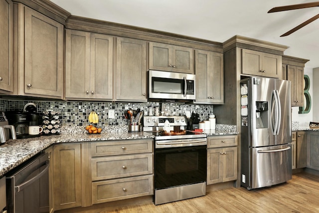 kitchen featuring dark stone countertops, backsplash, ceiling fan, light hardwood / wood-style floors, and stainless steel appliances