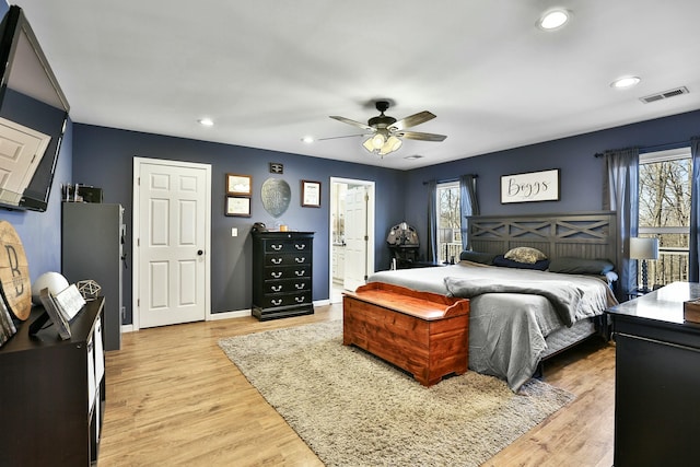 bedroom featuring multiple windows, connected bathroom, light hardwood / wood-style flooring, and ceiling fan