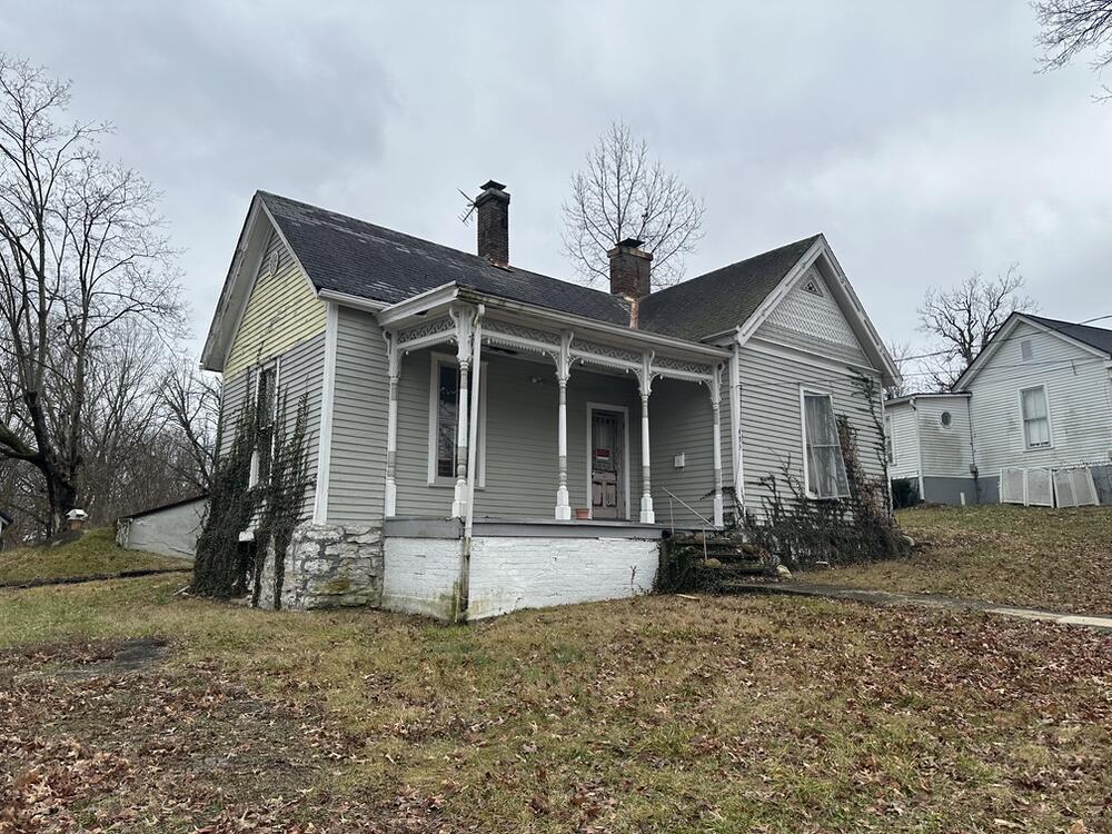 bungalow-style house featuring a front yard and covered porch