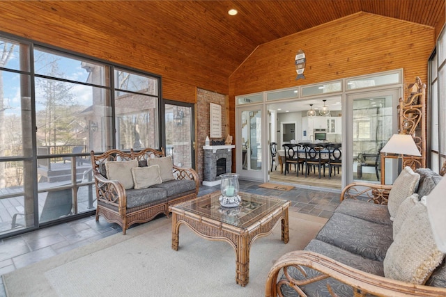 sunroom / solarium featuring wood ceiling, lofted ceiling, and a fireplace