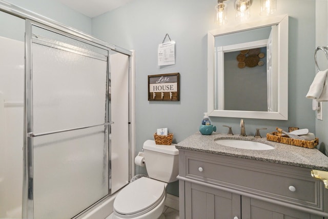 bathroom with vanity, toilet, and an enclosed shower