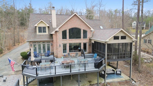 rear view of property with a sunroom and a deck