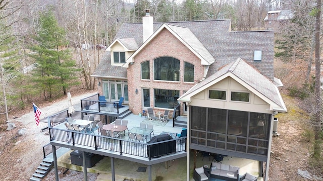 back of property with a wooden deck and a sunroom