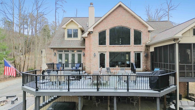 rear view of property with a wooden deck and a sunroom