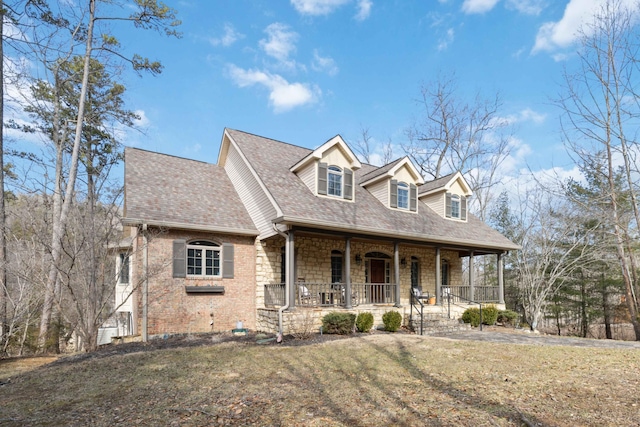 cape cod house featuring a front yard and covered porch