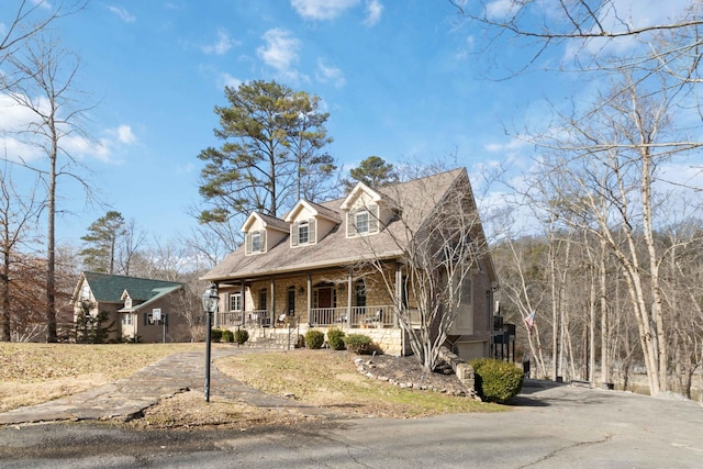 cape cod home featuring a porch