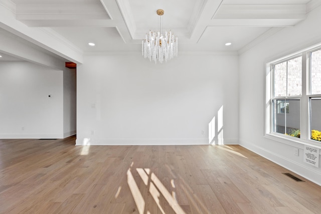 unfurnished room with beamed ceiling, ornamental molding, coffered ceiling, a notable chandelier, and light hardwood / wood-style flooring