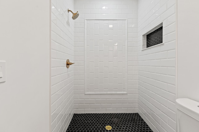 bathroom featuring toilet and tiled shower