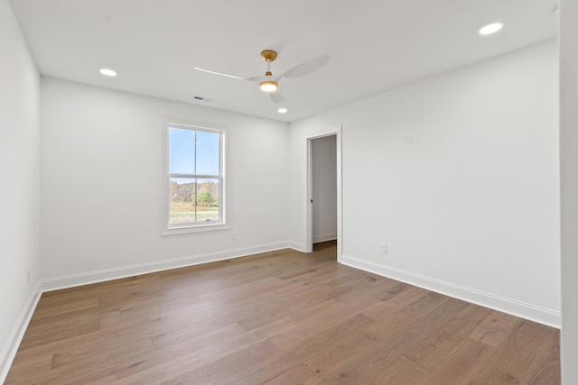 spare room with ceiling fan and light wood-type flooring