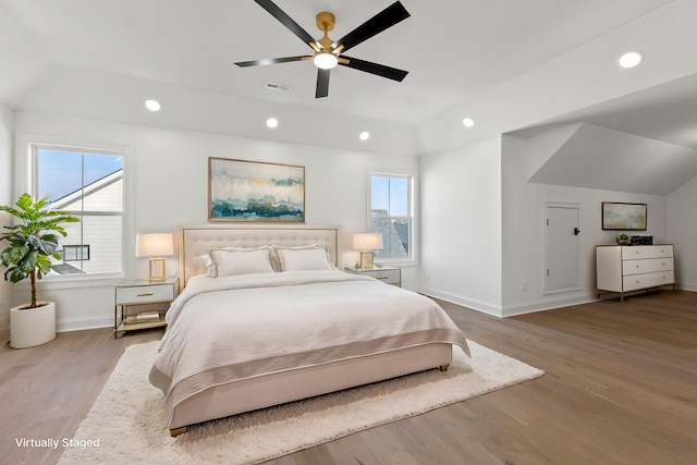 bedroom featuring hardwood / wood-style floors, vaulted ceiling, and ceiling fan