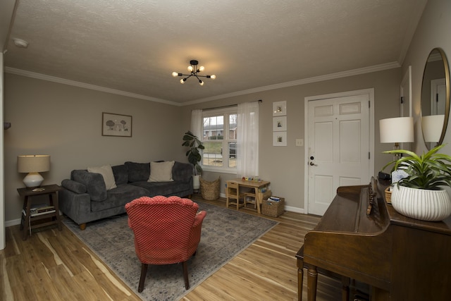 living room featuring an inviting chandelier, ornamental molding, hardwood / wood-style floors, and a textured ceiling