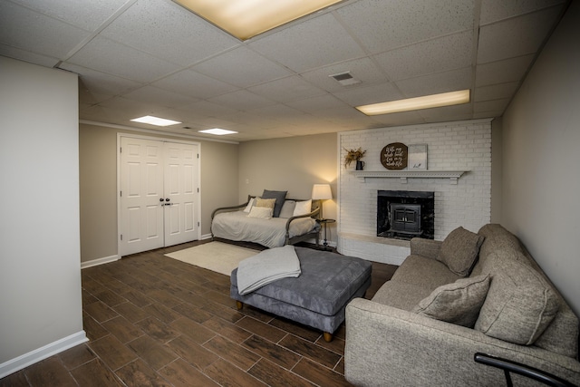 living room featuring dark wood-type flooring and a drop ceiling