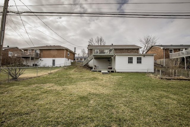 back of property featuring a wooden deck and a lawn