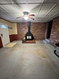 5 Keeton Ave, West Liberty, KY 41472 - basement with a wood stove, brick wall, and a ceiling fan
