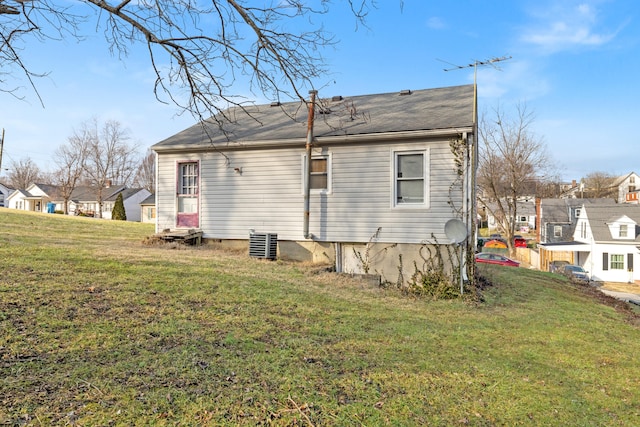 rear view of house with a lawn and central air condition unit