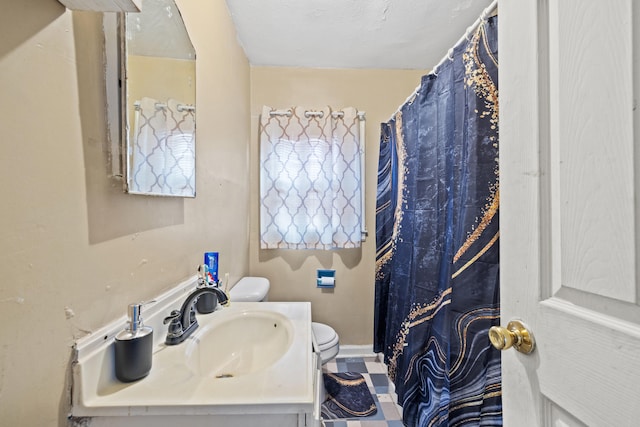 bathroom featuring vanity, a textured ceiling, and toilet