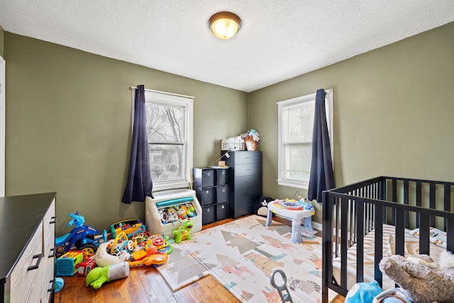 bedroom with light hardwood / wood-style floors and a textured ceiling