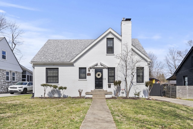 bungalow-style home featuring brick siding, roof with shingles, a chimney, and fence