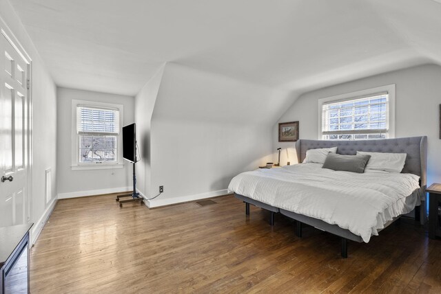 living area featuring lofted ceiling, wood finished floors, and baseboards