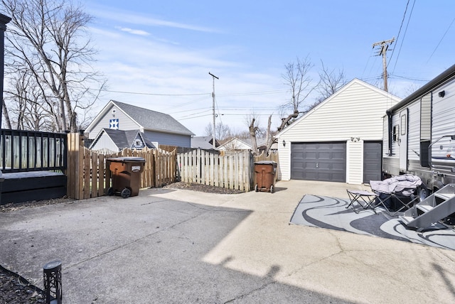 view of patio featuring an outbuilding, fence, and a garage