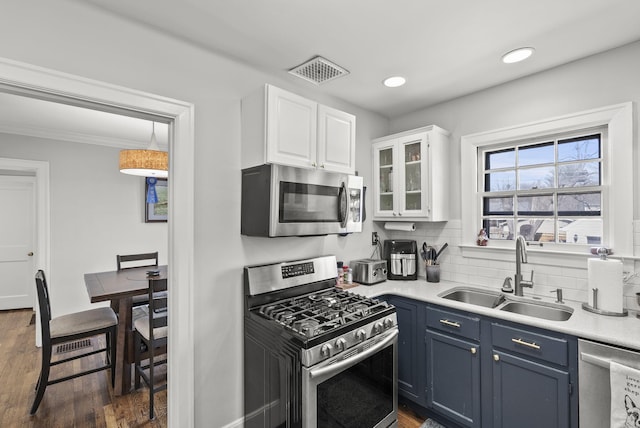 kitchen featuring visible vents, light countertops, appliances with stainless steel finishes, white cabinetry, and a sink