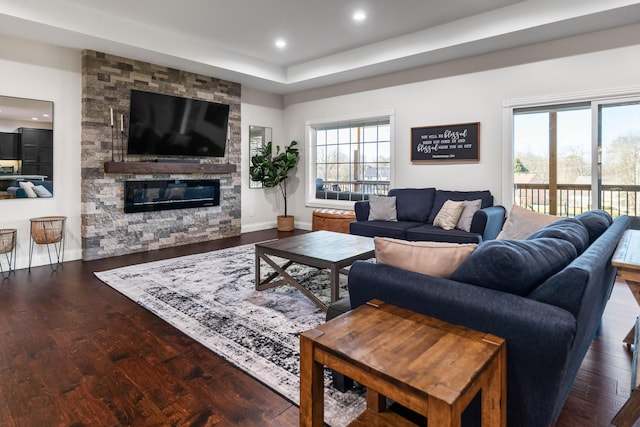 living room with a fireplace, dark hardwood / wood-style flooring, and a wealth of natural light