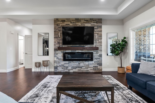 living room featuring dark wood-type flooring and a fireplace