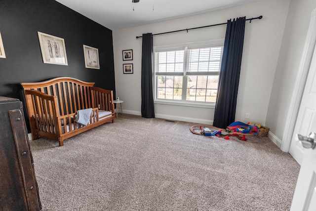 bedroom with a crib and carpet floors