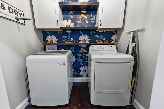 laundry area featuring cabinets, washing machine and clothes dryer, and dark wood-type flooring