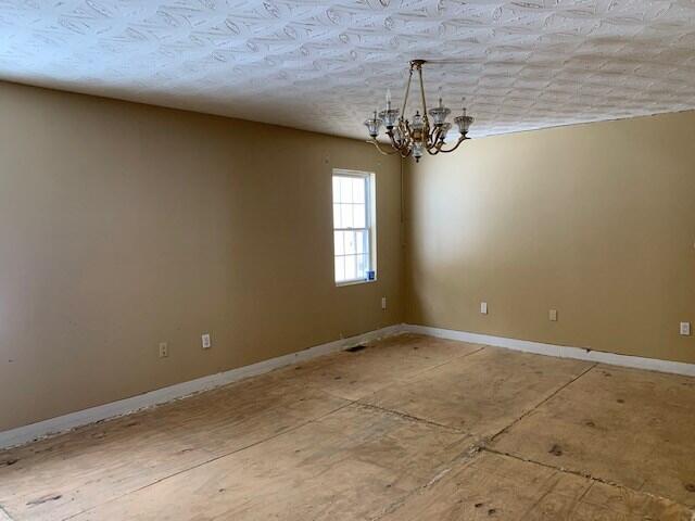 spare room with an inviting chandelier