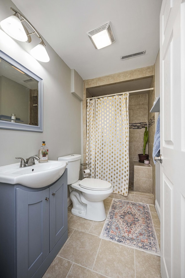 bathroom with visible vents, vanity, a tile shower, and toilet