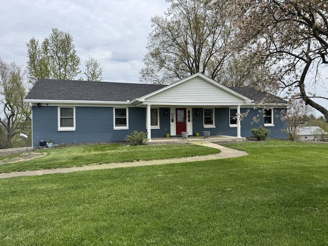 ranch-style house featuring brick siding, a porch, a shingled roof, and a front yard