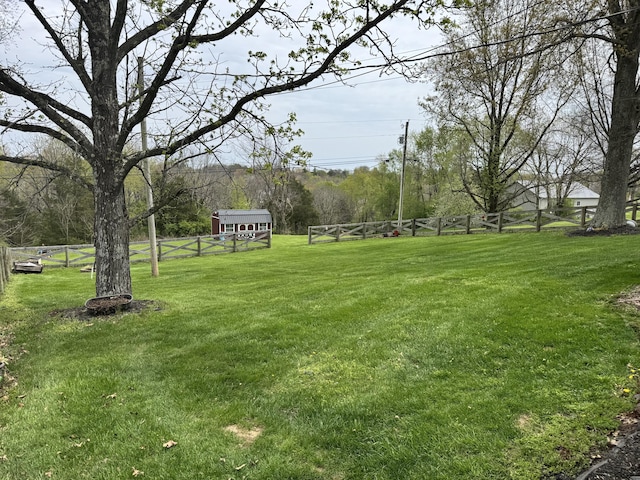 view of yard featuring fence and an outbuilding