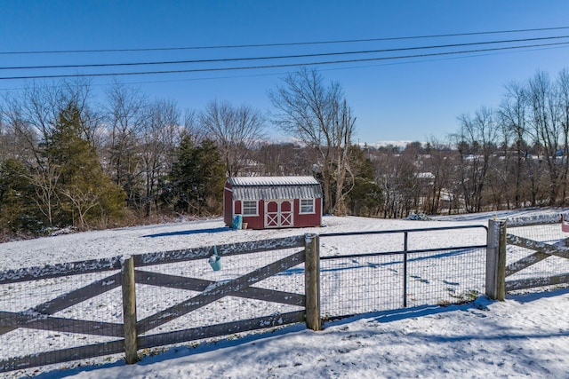yard covered in snow with fence, an outbuilding, and a storage shed