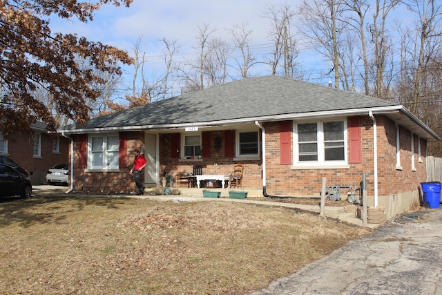 ranch-style home with a porch and a front lawn