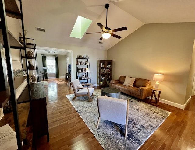 living room with lofted ceiling with skylight, ceiling fan, and dark hardwood / wood-style flooring