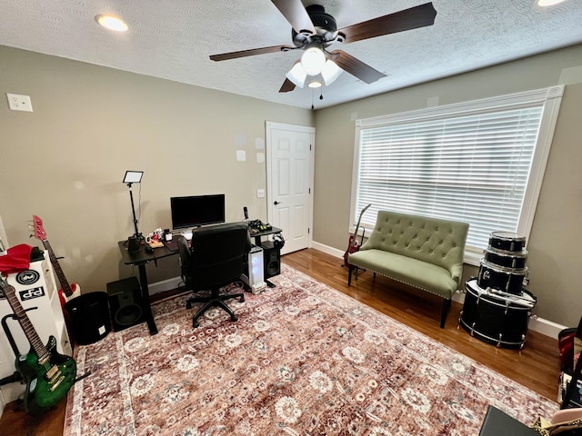 home office featuring wood-type flooring, ceiling fan, and a textured ceiling