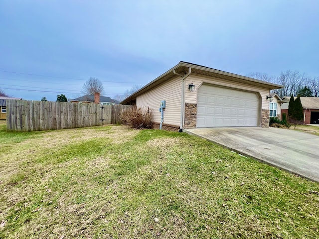 view of side of property featuring a garage and a lawn