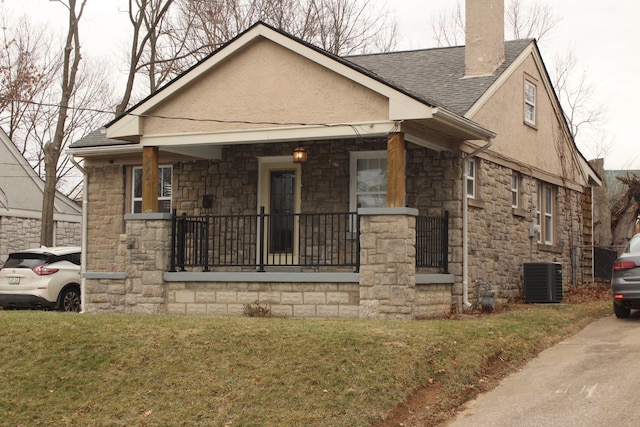 view of front facade with a front yard, covered porch, and central air condition unit