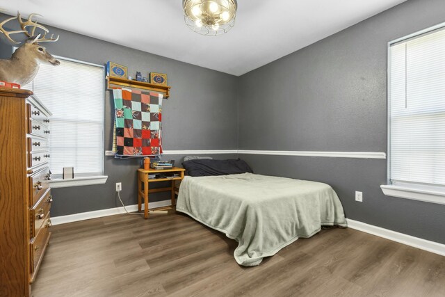 bedroom with dark hardwood / wood-style floors