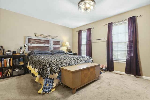 bedroom with multiple windows and light colored carpet