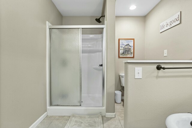 bathroom with tile patterned floors, toilet, and walk in shower