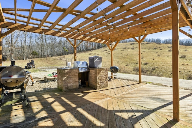 wooden terrace with area for grilling, a grill, and a pergola