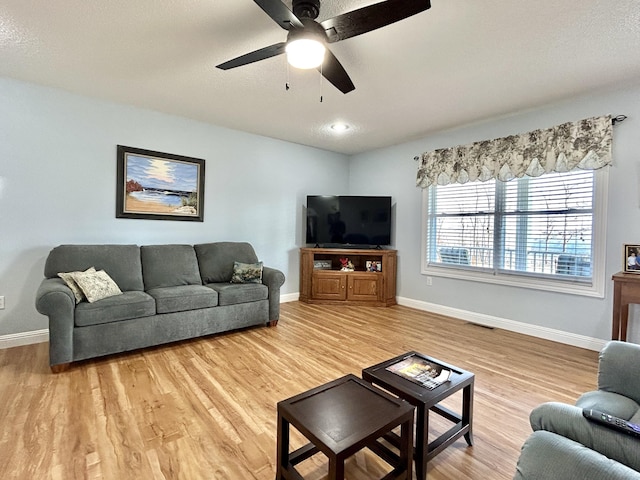 living room featuring hardwood / wood-style flooring, a textured ceiling, and ceiling fan