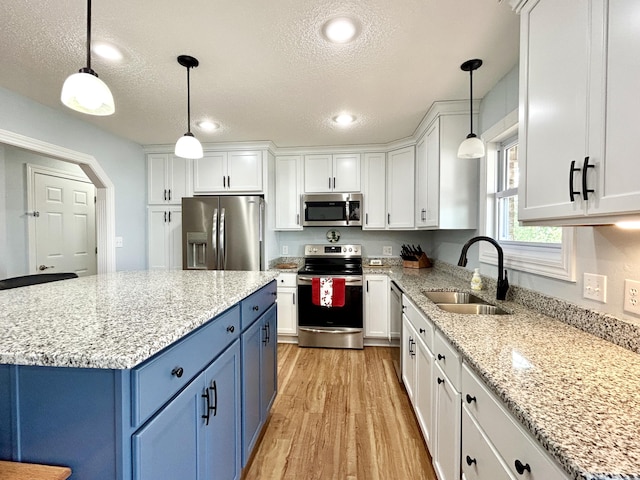 kitchen with white cabinetry, appliances with stainless steel finishes, and blue cabinetry