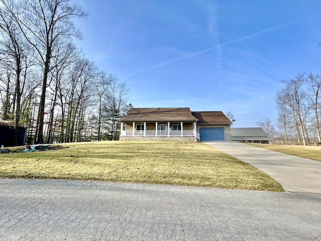 view of front of property featuring a garage, covered porch, and a front yard