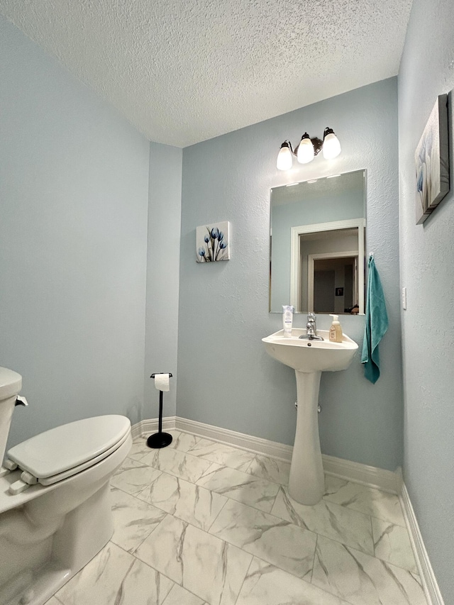 bathroom with a textured ceiling and toilet