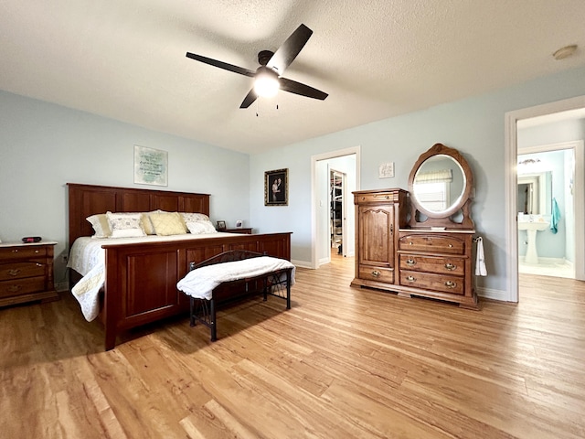 bedroom with ceiling fan, light hardwood / wood-style floors, and a textured ceiling