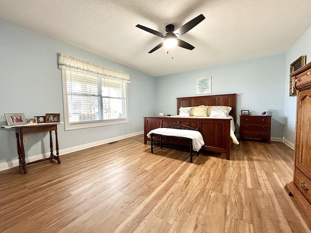 bedroom featuring ceiling fan, hardwood / wood-style floors, and a textured ceiling